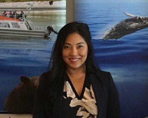 Westcoast Aquatic Safaris staff member in front of whale watching photo backdrop