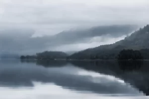 Misty lake with mountains and reflections