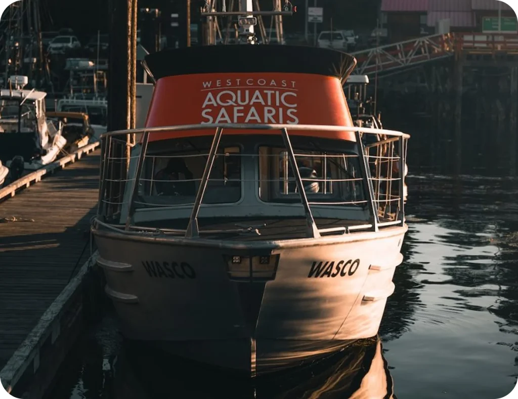 Westcoast Aquatic Safaris boat docked at a marina.